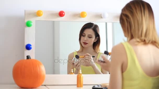 Vrouw toepassen van cosmetica op camera — Stockvideo