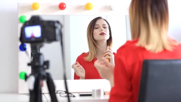 Vrouw toepassen van cosmetica op camera — Stockvideo