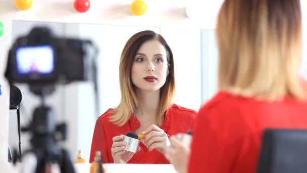 Mujer aplicando cosméticos en la cámara — Vídeo de stock