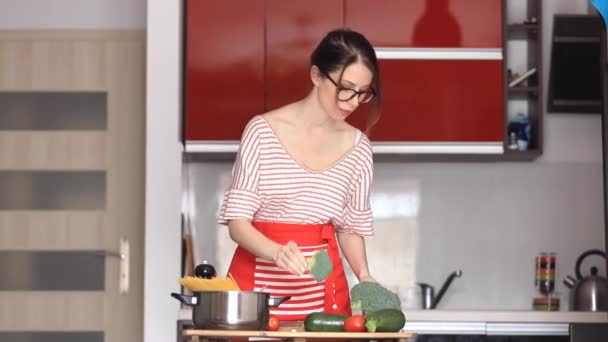 Giovane donna cucina a macchina fotografica — Video Stock