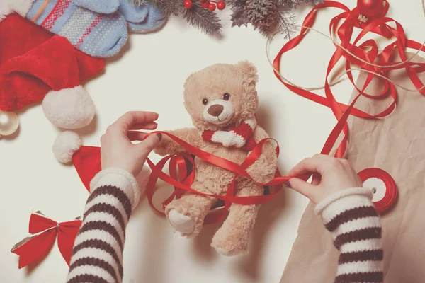 Woman wrapping teddy bear — Stock Photo, Image