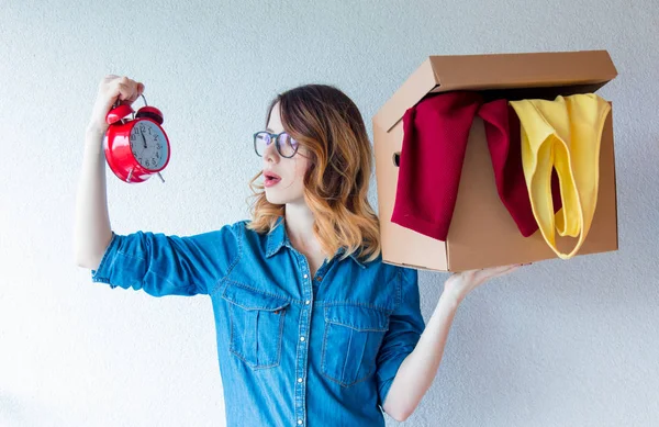 Frau hält Box und Wecker in der Hand — Stockfoto