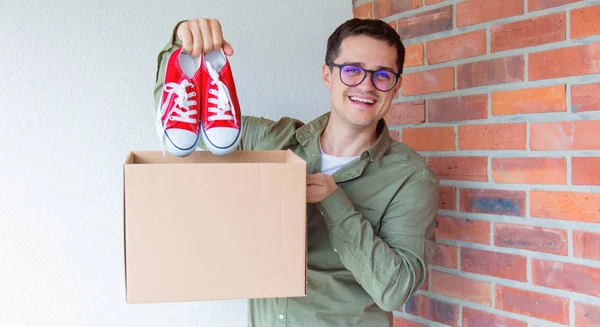 Man bedrijf vak en sneakers — Stockfoto