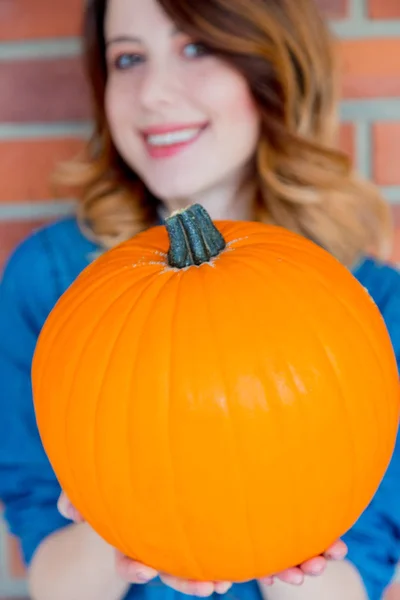 Frau zeigt orangefarbenen Kürbis — Stockfoto