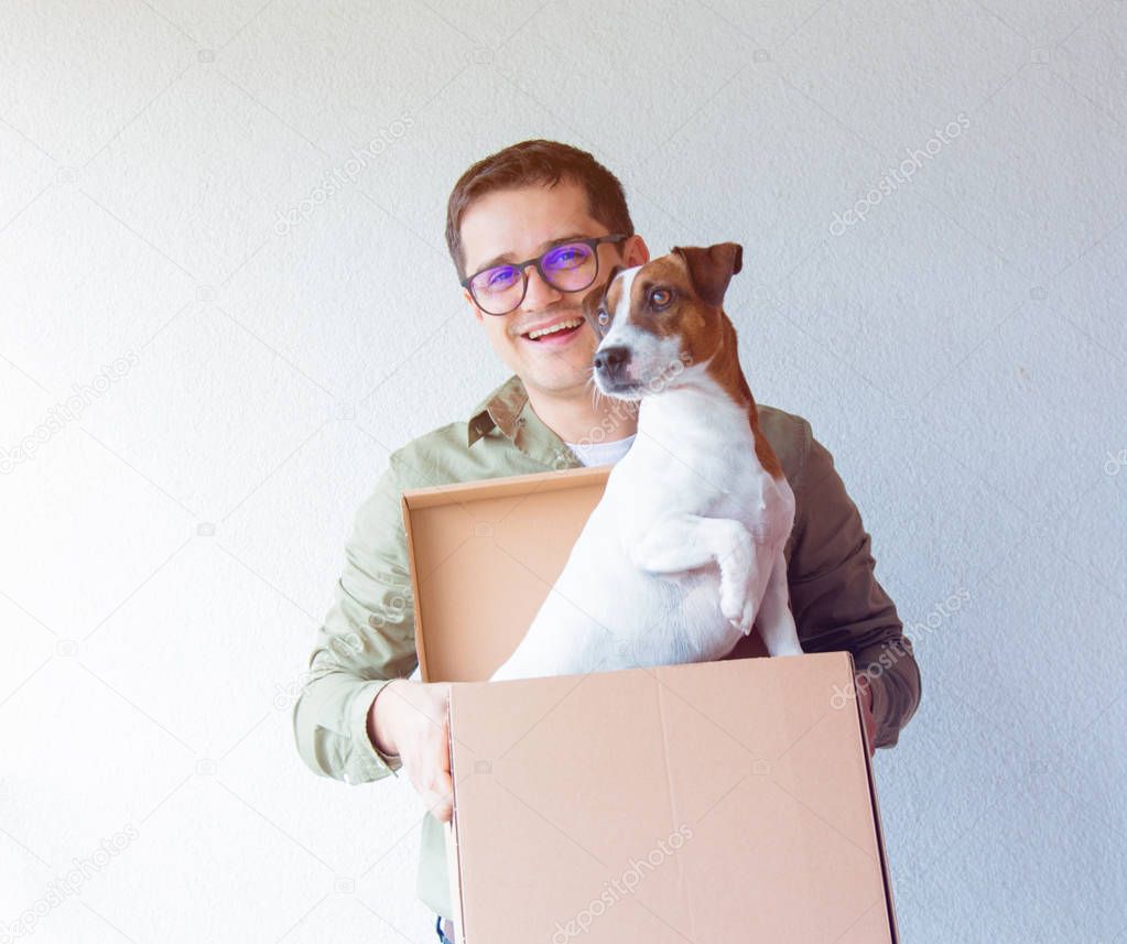 man holding cardboard box with dog