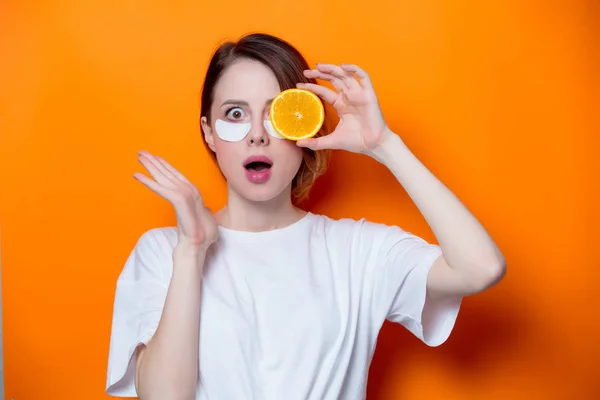 Женщина держит кусочек апельсина — стоковое фото