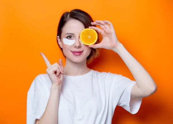 Mulher segurando fatia de laranja — Fotografia de Stock