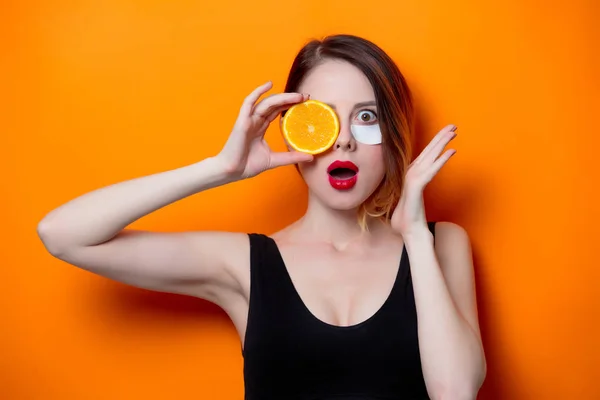 Woman holding orange slice — Stock Photo, Image