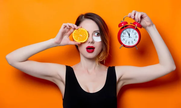 オレンジ スライスと目覚まし時計女性 — ストック写真