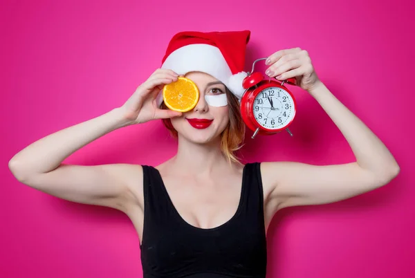 Woman with orange slice and alarm clock — Stock Photo, Image