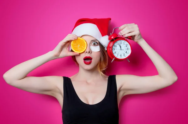 Mujer con rebanada naranja y despertador — Foto de Stock