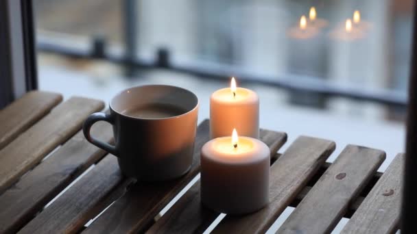 Φλιτζάνι καφέ και κεριά που στέκεται στο τραπέζι — Αρχείο Βίντεο
