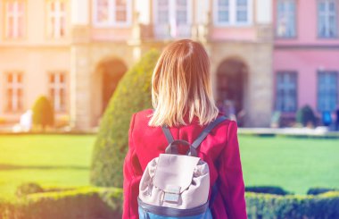 Sırt çantası bir şatoda olan Kızıl saçlı kadın 