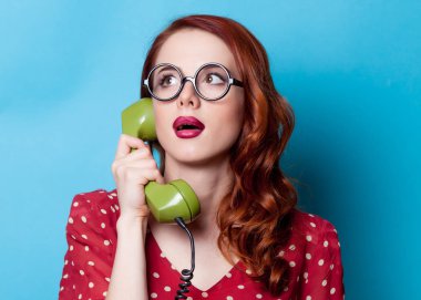 Kızıl saçlı ev kadını telefonla konuşuyor