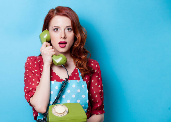 Рыжая домохозяйка разговаривает по телефону
