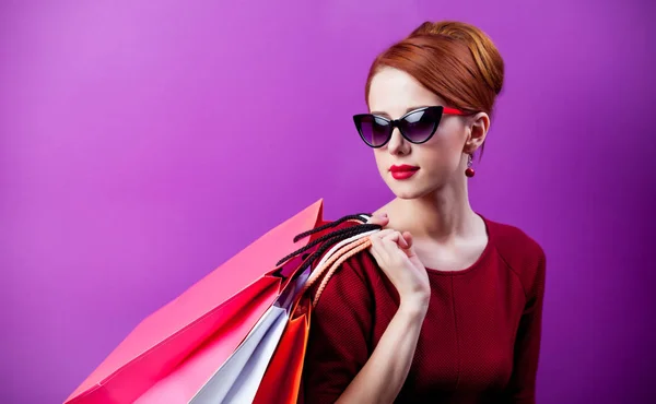 Femme en lunettes de soleil avec sacs à provisions — Photo