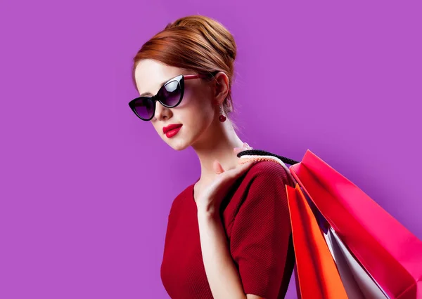 Femme en lunettes de soleil avec sacs à provisions — Photo