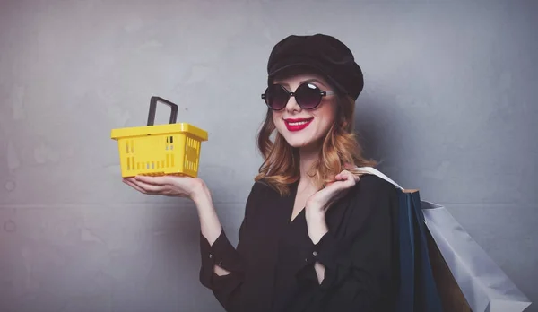 Menina com sacos de compras e cesta — Fotografia de Stock