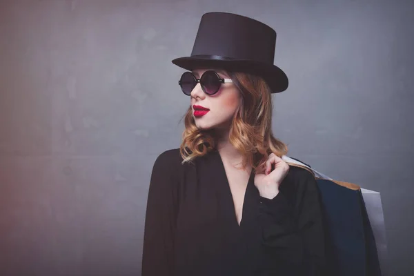 Menina de chapéu com sacos de compras — Fotografia de Stock