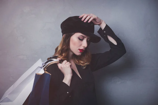 Mulher de chapéu com sacos de compras — Fotografia de Stock