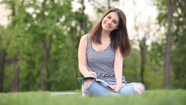 Estudiante con cuaderno en el parque — Vídeo de stock