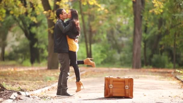Пара обнимается рядом с чемоданом — стоковое видео