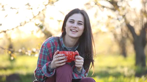 Женщина в рубашке с красной чашкой — стоковое видео