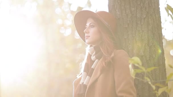Ruda Kobieta w kapeluszu, jesienny Park — Wideo stockowe