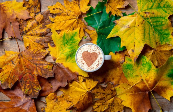 Cappuccino con forma de corazón en hojas de arce —  Fotos de Stock