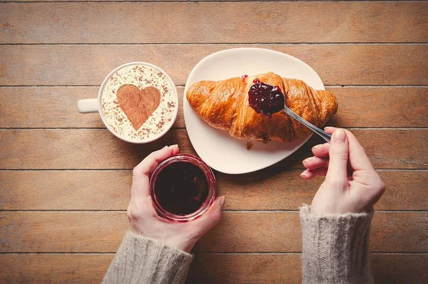 Breakfast croissaint near cup of coffee on wooden table — Stock Photo, Image