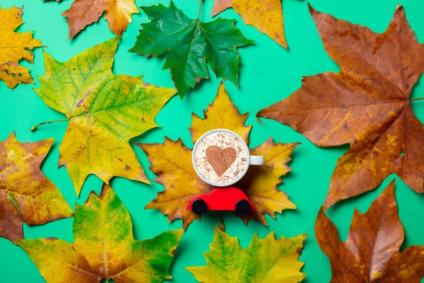 Cappuccino con forma de corazón en hojas de arce — Foto de Stock