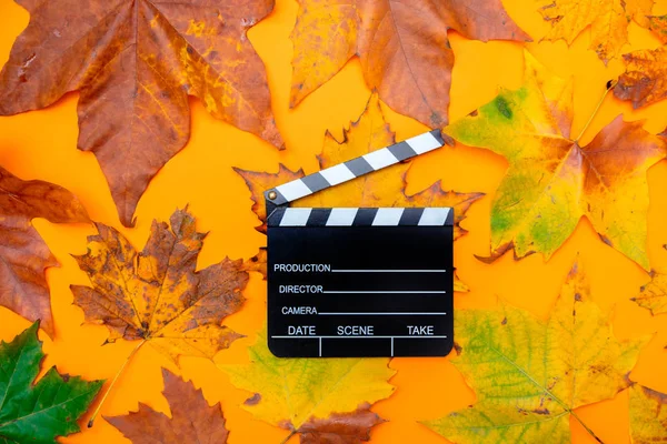 Tablero de aplausos de película y hojas de arce —  Fotos de Stock