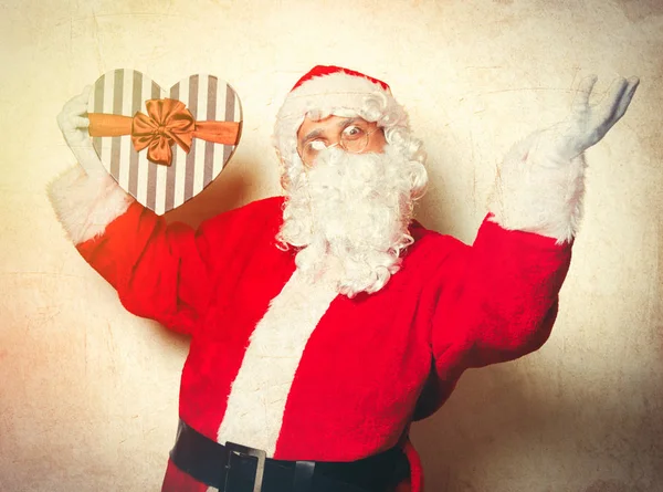 Funny Santa Claus holding heart shape gift — Stock Photo, Image