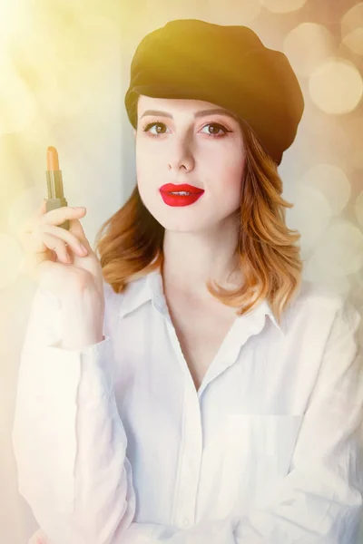 Vrouw in bedrijf lippenstift hoed — Stockfoto