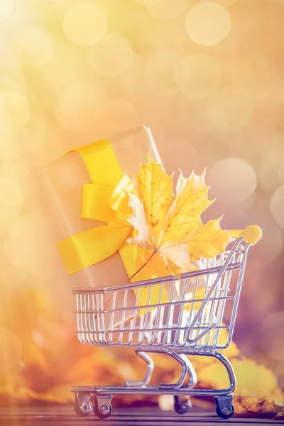 Chariot avec cadeau et feuilles d'érable — Photo