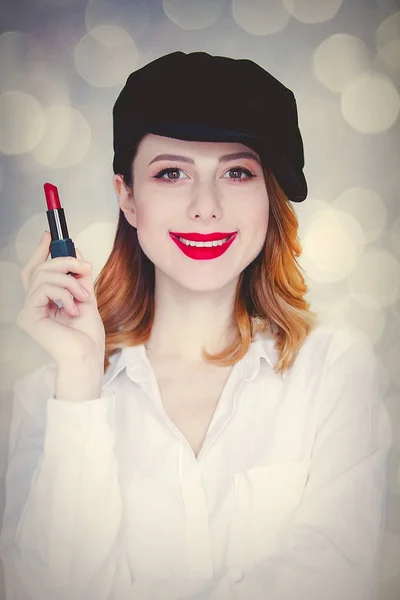 Niña sonriente sosteniendo lápiz labial rojo — Foto de Stock