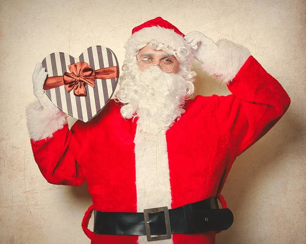 Funny Santa Claus Sosteniendo Caja Regalo Forma Corazón Tocando Sombrero —  Fotos de Stock