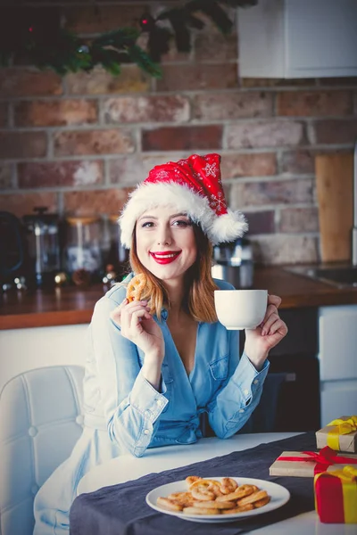 Girl in Santa hat drinking tea — Stock Photo, Image