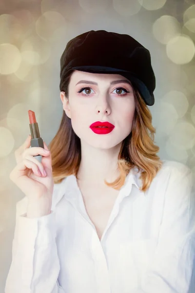 Mujer en sombrero sosteniendo lápiz labial — Foto de Stock