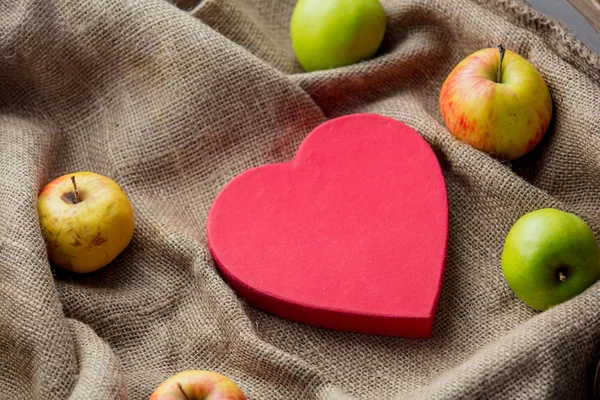 แอปเปิ้ลและของขวัญบนพื้นหลัง jute — ภาพถ่ายสต็อก