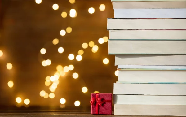 Pile of books on fairy lights — Stock Photo, Image