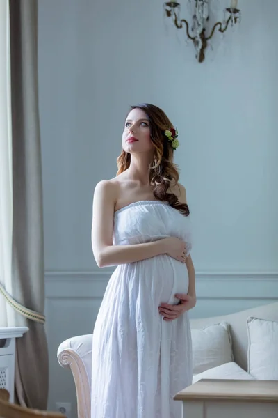 Gravid kvinna i vit klänning — Stockfoto