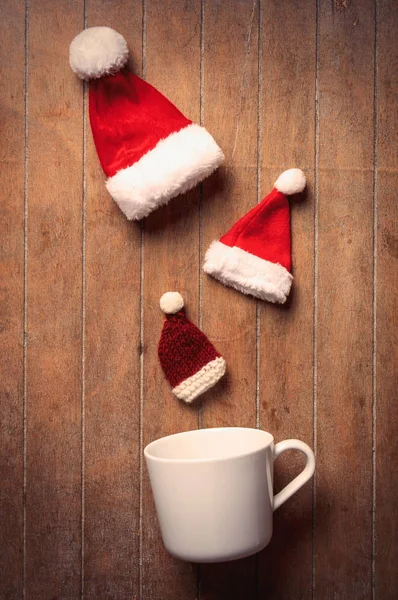 Noel Baba şapkaları ile beyaz fincan — Stok fotoğraf