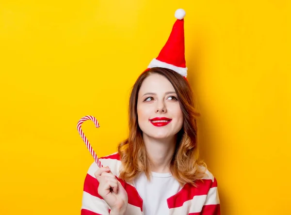 Donna in cappello Babbo Natale con canna da zucchero — Foto Stock