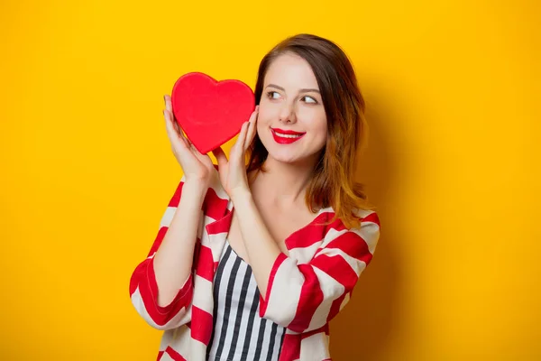 Lächelnde Junge Rothaarige Frau Zeigt Herzförmige Geschenkschachtel Zum Valentinstag Auf — Stockfoto