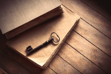 Vintage anahtar ve ahşap masa üzerinde eski kitaplar.
