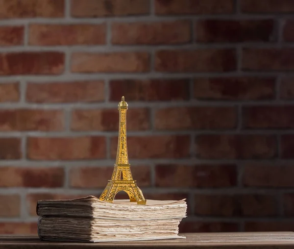 Recuerdo de la torre Eiffel dorada y libros antiguos — Foto de Stock