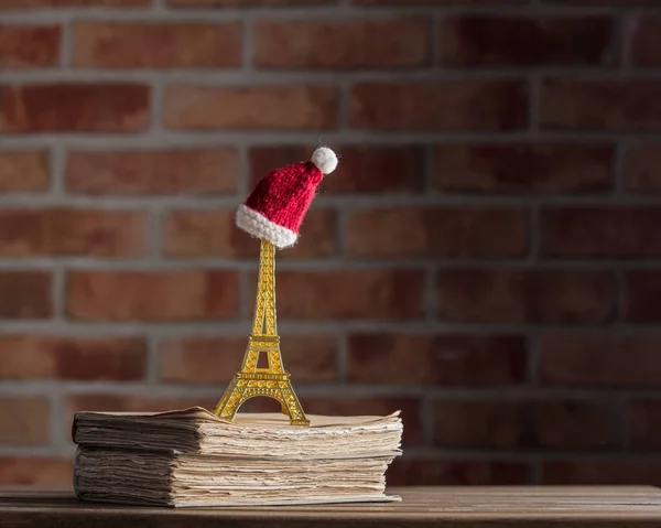 Рождественская шляпа на Эйфелевой башне сувенир и старые книги — стоковое фото