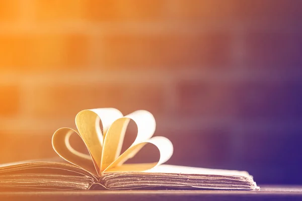 Old book on wooden table at fairy lights background — Stock Photo, Image