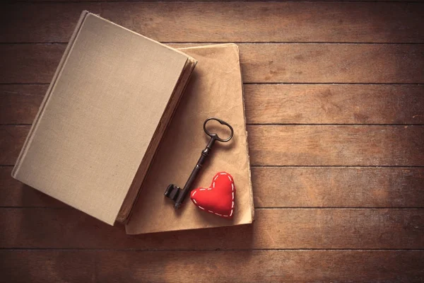 Llave vintage con forma de corazón y libros antiguos — Foto de Stock